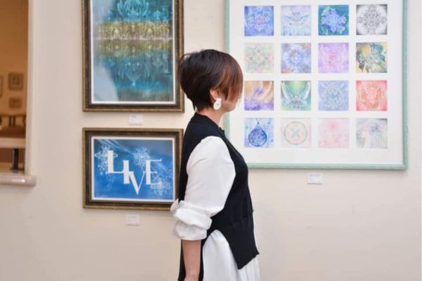 飾られた絵を見ている講師